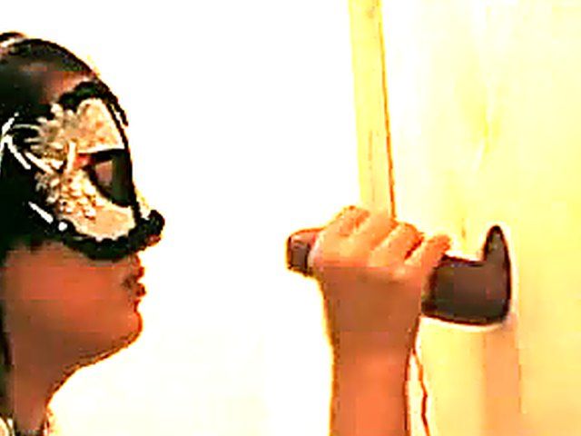 Masked slut sucks cock in a glory hole