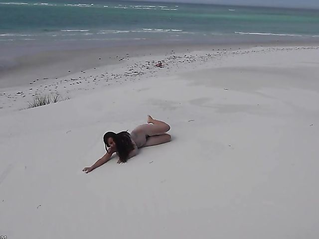 Jasmine Summers posing nude in sand by the ocean  