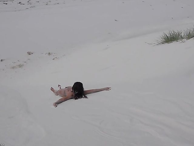 Jasmine Summers posing nude in sand by the ocean  