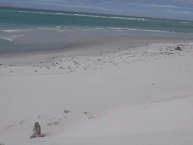 Jasmine Summers posing nude in sand by the ocean  
