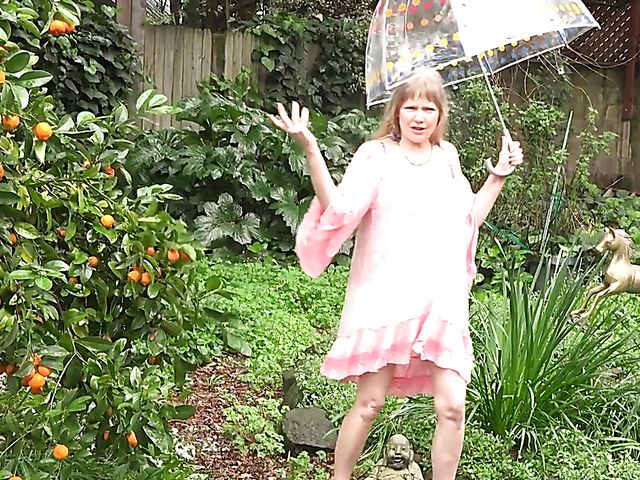 Flirty mature woman shows her boobs in the garden on a rainy day and masturbates at home