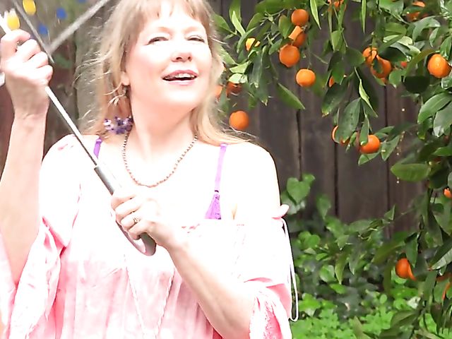 Flirty mature woman shows her boobs in the garden on a rainy day and masturbates at home