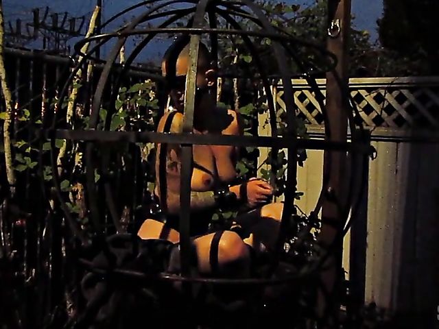 Caning punishment for caged slave Abigail Dupree in the garden