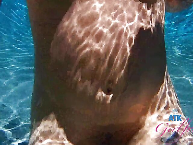 Babyfaced asian Mi Ha Doan swimming naked in the pool