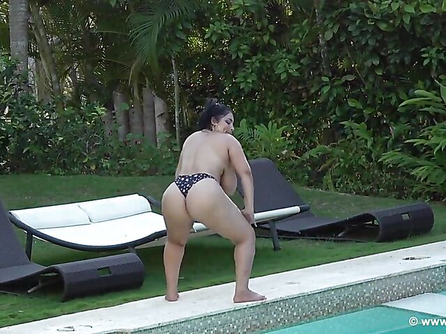 Curvy bikini woman Issy goes topless and oils her giant tits outdoors