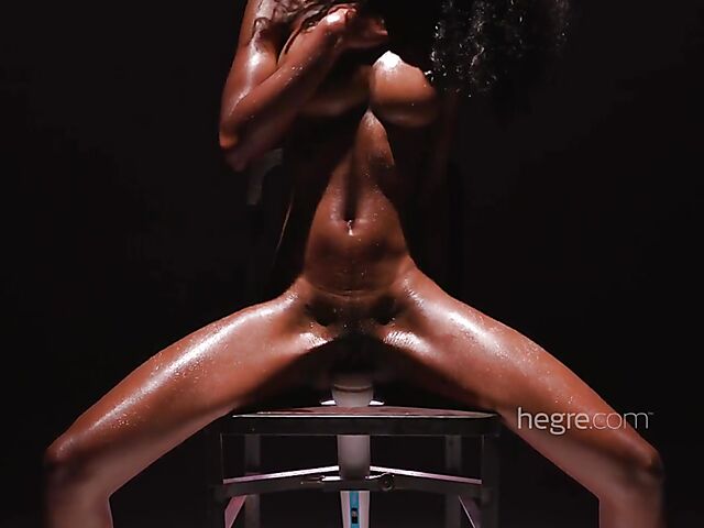 Sweaty ebony Katherina riding a chair with a magic wand in it