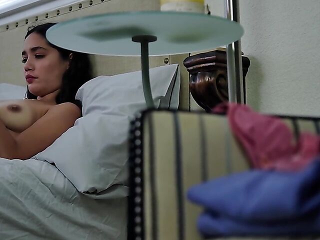 Brunette nurse Luz masturbating next to a sleeping guy in his bed