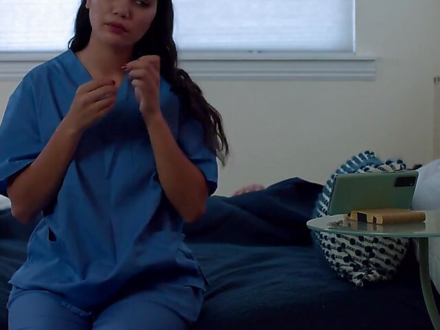 Brunette nurse Luz masturbating next to a sleeping guy in his bed