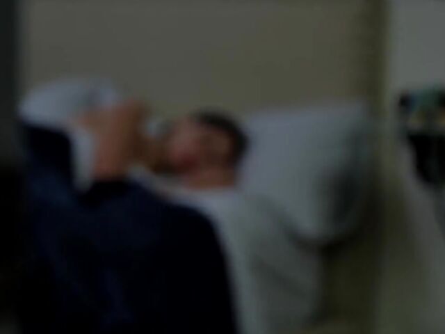 Brunette nurse Luz masturbating next to a sleeping guy in his bed