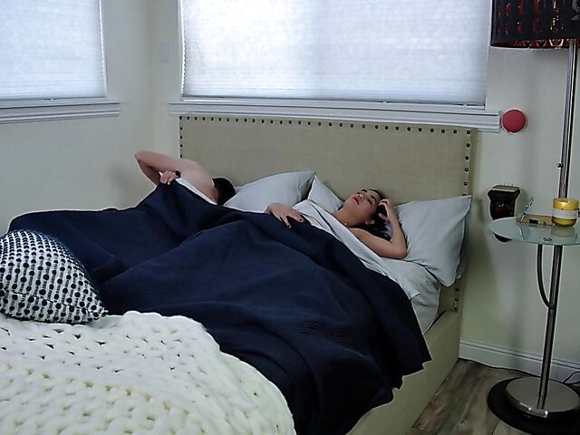 Brunette nurse Luz masturbating next to a sleeping guy in his bed