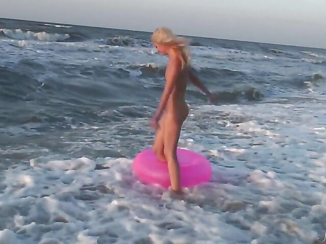 Nudist teen Agnes poses on the beach and takes a dip