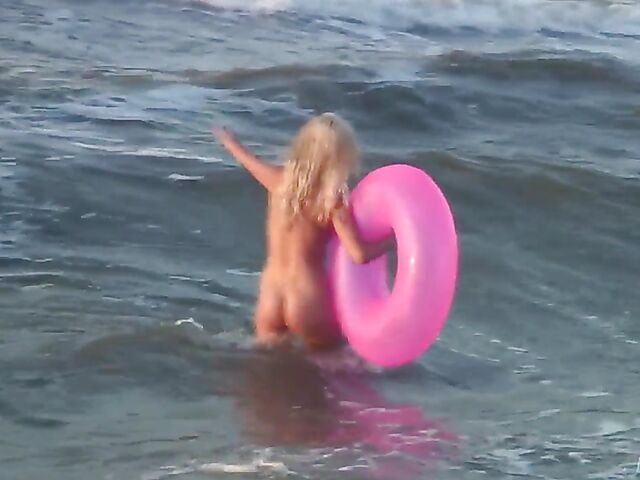 Nudist teen Agnes poses on the beach and takes a dip