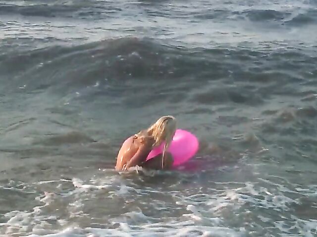 Nudist teen Agnes poses on the beach and takes a dip