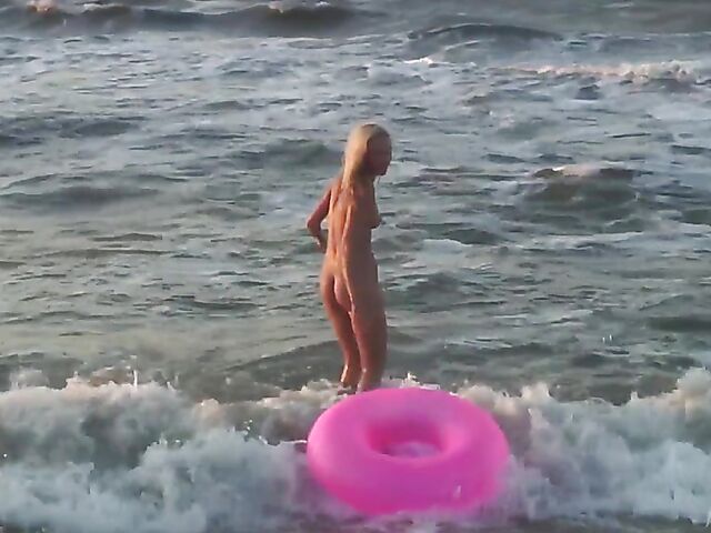 Nudist teen Agnes poses on the beach and takes a dip
