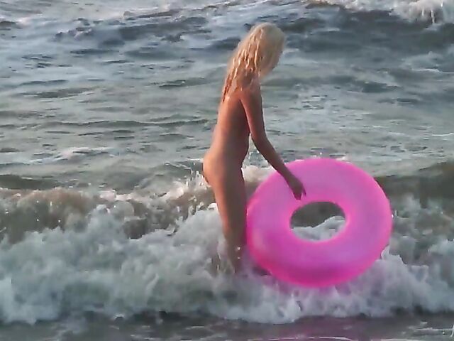 Nudist teen Agnes poses on the beach and takes a dip