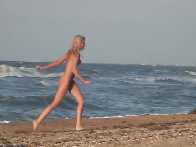 Nudist teen Agnes poses on the beach and takes a dip