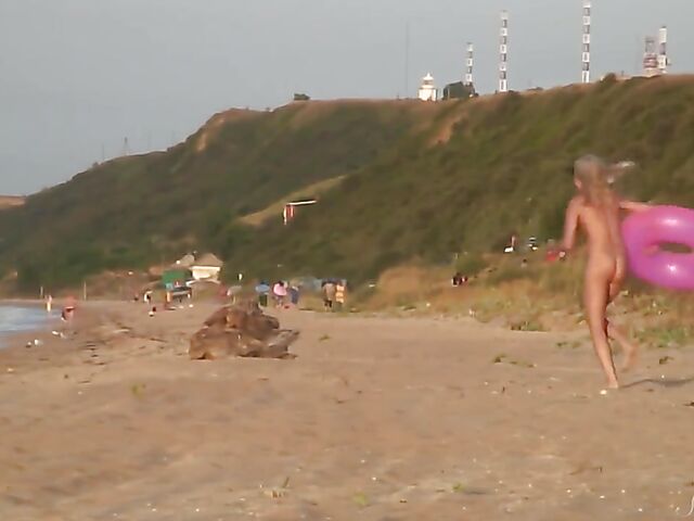 Nudist teen Agnes poses on the beach and takes a dip