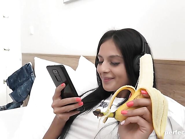 Young brunette Mia.Trejsi eating a banana and fingering her snatch in her bed