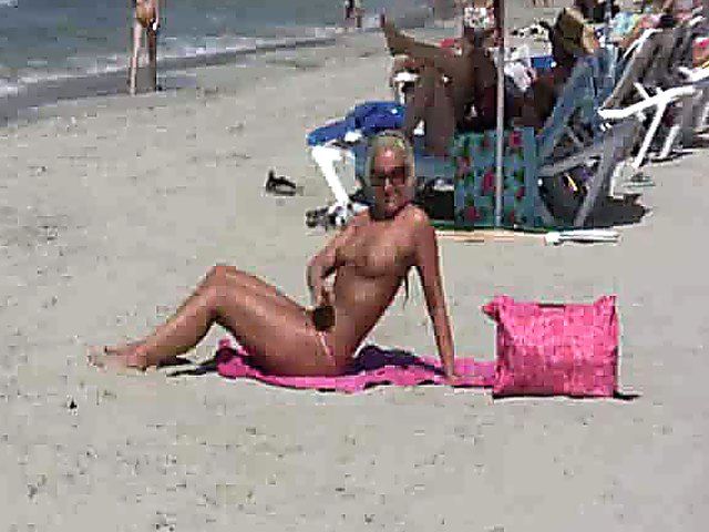 Tanning MILF on beach is exhibitionist