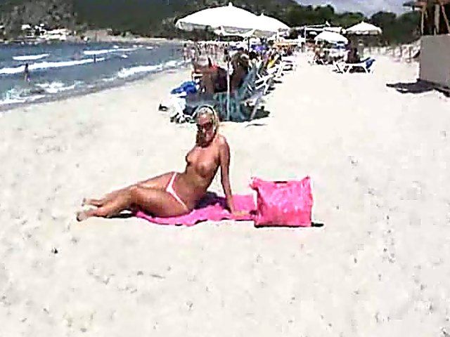 Tanning MILF on beach is exhibitionist