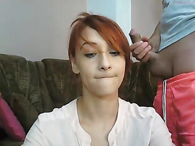 Naughty girl posing in shorts and giving webcam blowjob