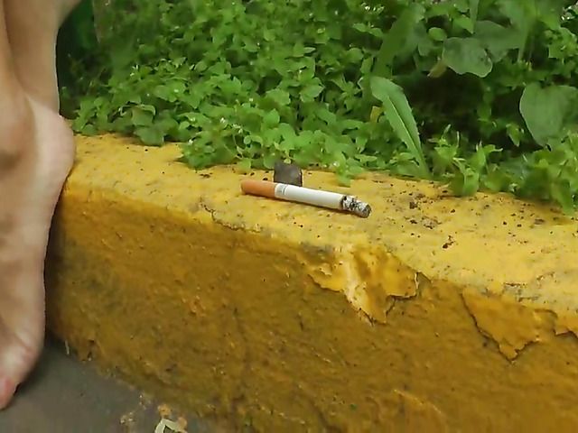 Barefoot amateur with dirty soles in the street