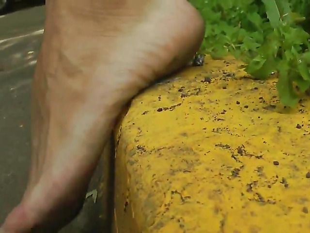 Barefoot amateur with dirty soles in the street