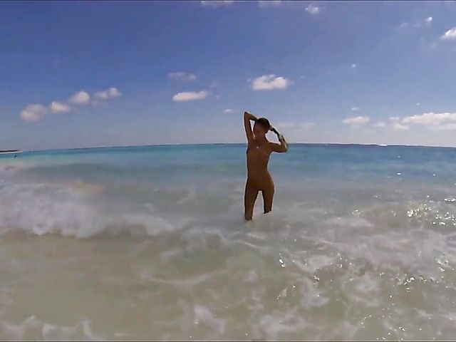 Sexy babe poses naked on the beach and skinny dip