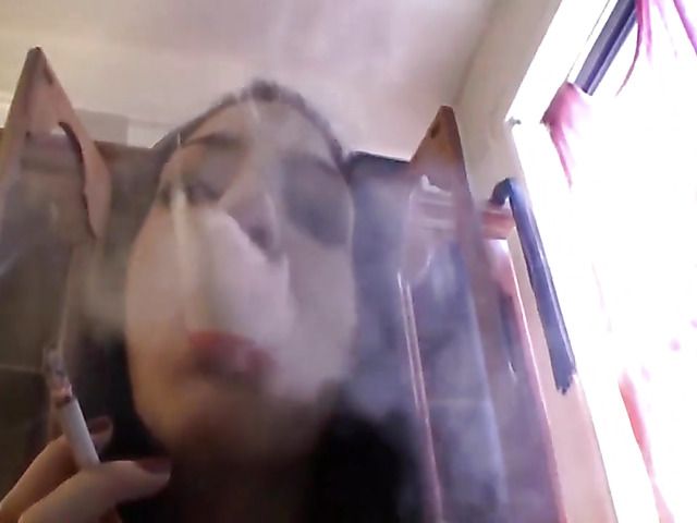 Tattooed amateur brunette smoking on camera