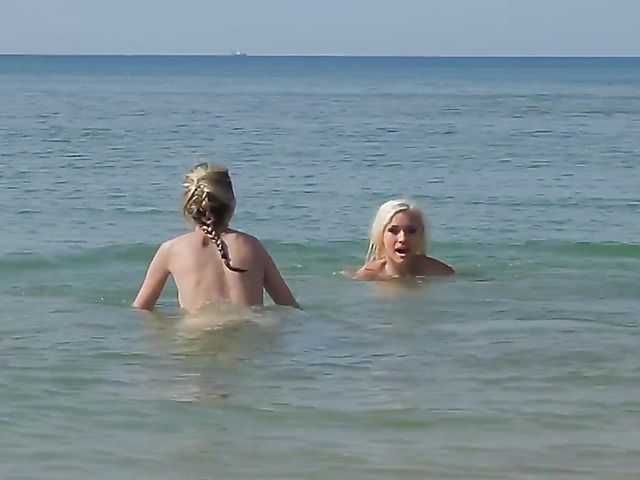Two playful bikini girls get naked on the beach