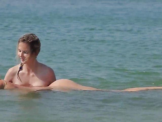 Two playful bikini girls get naked on the beach