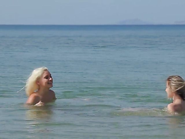 Two playful bikini girls get naked on the beach