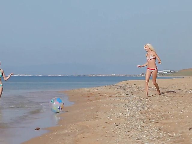 Two playful bikini girls get naked on the beach