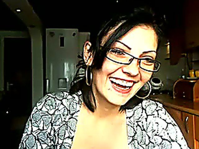 Pretty brunette strokes her pussy in the kitchen