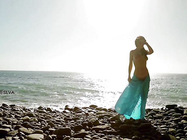 Elina Azure posing nude and fingering her slit by the sea